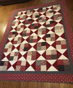 a red and white quilt is laying on the floor