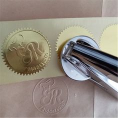 a stamper and some paper on top of a piece of brown paper with a gold seal