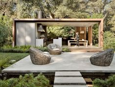 an outdoor living area with furniture and trees in the background