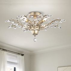 a living room with white walls and a chandelier hanging from it's ceiling