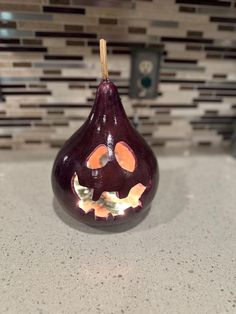 a purple pear with a face drawn on it