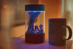 a glass jar filled with water and two figurines sitting on top of a table