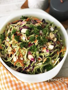 a white bowl filled with broccoli and carrots