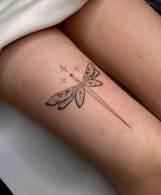 a woman's leg with a tattoo on it and a dragonfly sitting on top