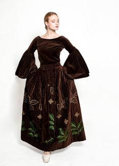 Experience the subtle elegance of the Adolfo 1969 Choc Brn Velvet Embroidered Skirt Set. From the fall winter 1969-1970 collection, this documented masterpiece is crafted from velvet with intricate embroidery for a timeless, luxurious look. Explore the beauty of Adolfo's maxi skirt and bell sleeve top, and revel in its exceptional value. Condition: Excellent Vintage Condition Material: Velvet, Metallic Embroidery Sleeve Style: Bell sleeves Neckline: Elegant jewel neckline Closure: Metal Zipper, Velvet Maxi Skirt Outfit, Satin Suit, Metallic Embroidery, Red Carpet Ready, Subtle Elegance, Antique Dress, Jewel Neckline, Embroidered Skirt, Intricate Embroidery