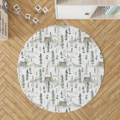 a round rug with trees and animals in the middle on a wooden floor next to dices