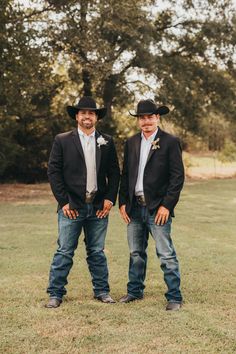 two men standing next to each other wearing cowboy hats