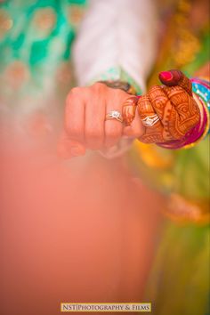 a close up of a person holding something in their hand and wearing jewelry on her wrist