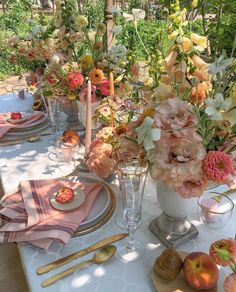 an outdoor table set with flowers, plates and utensils for dinner or brunch