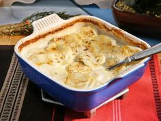 a blue casserole dish filled with mashed potatoes and topped with gravy