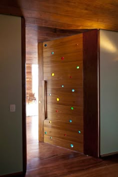 an open door with multicolored rocks on the side and wood paneling around it