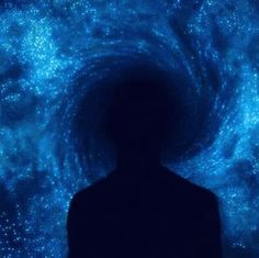 a man standing in front of a blue and black spiral background with stars on it