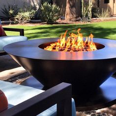 an outdoor fire pit with chairs around it