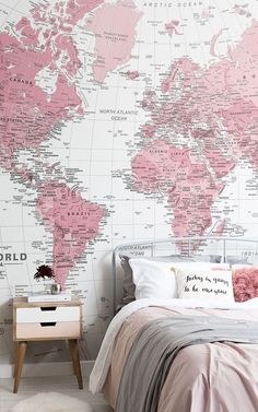 a bedroom with a large pink world map on the wall and bed in front of it