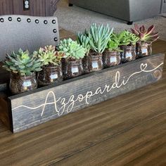 a wooden sign with candles and succulents on it that says, agoradi