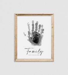 a black and white hand print with the word family on it in a wooden frame