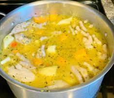 a pot filled with chicken and vegetables on top of a stove