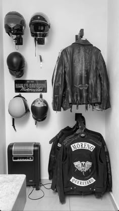 motorcycle helmets and jackets are hanging on the wall