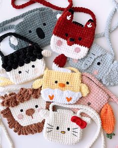 several crocheted animal purses are arranged on a white surface with red string