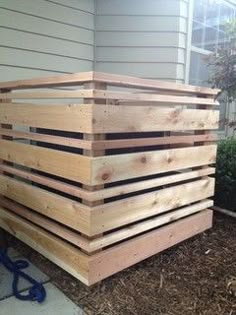 a large wooden box sitting on the side of a house