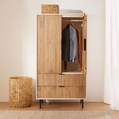 a wooden cabinet with clothes hanging on it