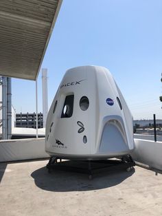 the spacex capsule is on display in front of a building with a sky background