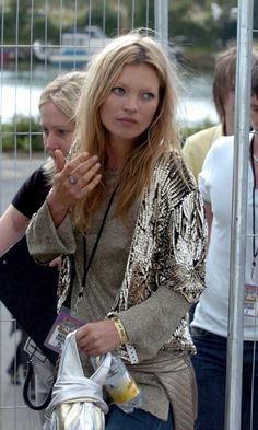 a woman standing next to a metal fence