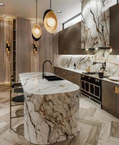 a kitchen with marble counter tops and stainless steel appliances, along with pendant lights hanging from the ceiling