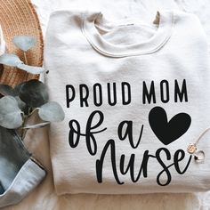 a white shirt with the words proud mom of a nurse on it next to a potted plant