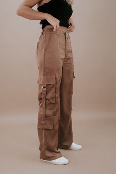 The Silk Cargo Pants in Coco are a luxurious and versatile addition to your wardrobe. These cargo pants offer a blend of comfort and style. The coco color exudes elegance, and the silk material adds a touch of refinement to your look. Silk cargo pants Two back pockets Two side hip pockets Three cargo pockets Button and zipper closure Belt loops Elastic waistband in the back for added comfort Fabric Contents: 100% POLYESTER Inseam: Small 30 in Medium 30.25 in Large 30.50 in Rise: Small 11.25 in M Luxury Wide Leg Brown Cargo Pants, Luxury Cotton Cargo Jeans For Fall, Luxury High-waisted Cargo Pants With Patch Pockets, Luxury Khaki Cargo Style Bottoms, Luxury Wide Leg Cargo Pants For Women, Luxury Spring Pants With Cargo Pockets, Luxury Casual Pants With Cargo Pockets, Luxury Chic Cargo Pants With Patch Pockets, Luxury High-waisted Cargo Pants With Side Pockets