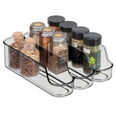 the spice rack is holding several different types of spices and seasonings in glass containers