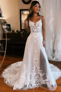 a woman standing in front of a mirror wearing a wedding dress