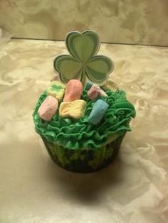 a cupcake with green frosting and shamrock decorations