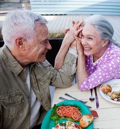 an older couple sitting at a table with food