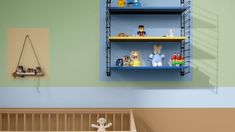 a baby's room with shelves and toys on the wall next to a crib