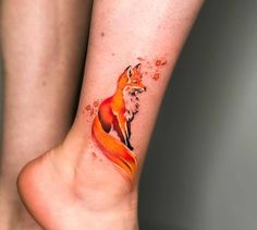 a woman's foot with a tattoo of a red fox on her left leg