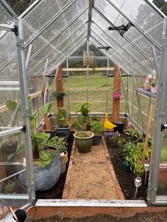 the inside of a small greenhouse with plants in it