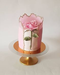 there is a pink cake with a rose on it