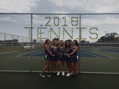 a group of young women standing next to each other on a tennis court