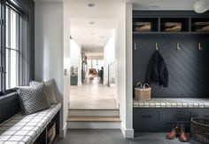 the entryway is decorated in black and white, with built - in storage units