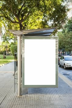 an empty bus stop with a white sign on it