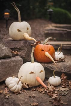 pumpkins with faces carved into them sitting on the ground