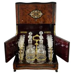 an antique wooden case with three glass decanters and two matching candlesticks