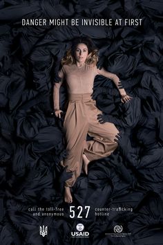 a woman laying on top of a pile of black cloths with the words danger might be invisible at first