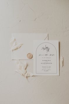 the wedding stationery is laid out on top of an envelope with a wax stamp