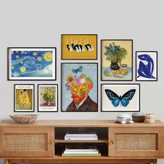 a wooden table topped with lots of pictures and art on it's sideboard