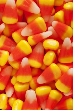 a pile of candy corn on top of each other in yellow, orange and red