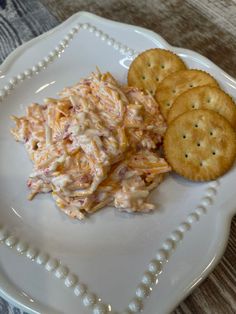 a white plate topped with crackers and coleslaw next to two crackers