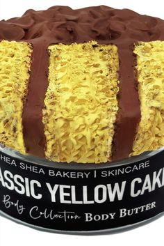 a cake in a tin with chocolate icing and yellow frosting on the top