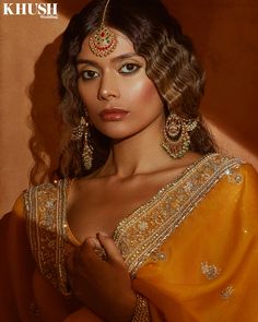 a woman in an orange sari and gold jewelry